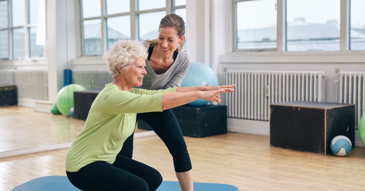 personal trainer training elderly woman<br>